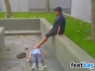 Foot worshipping outdoors at a park