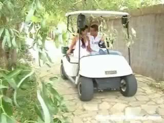 A lassie and her young man are driving around in a golf cart. Suddenly they stop and the stripling starts to touch the girl up,